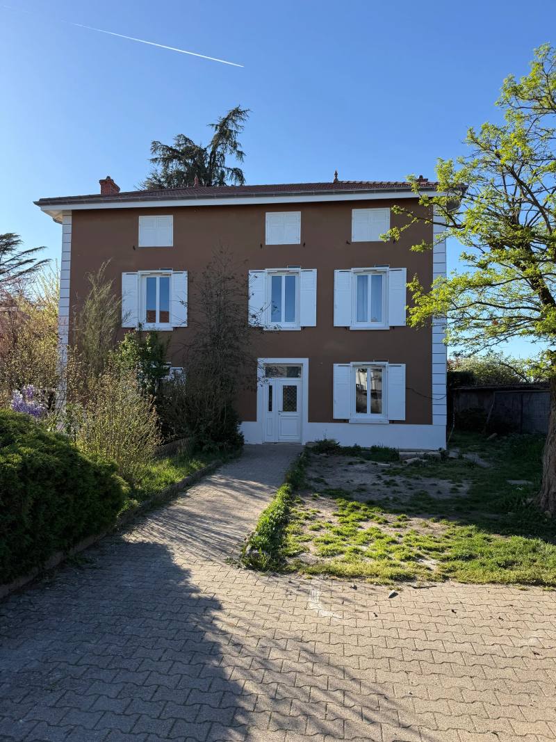 Maison de maître à la façade rouge brique, encadrements et chaînes d'angle blancs
