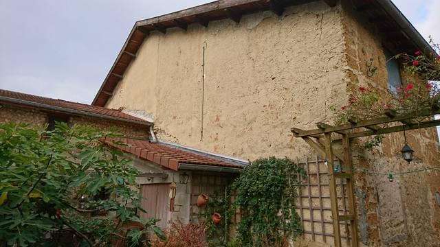 Mur en terre à l'enduit usé, avant rénovation