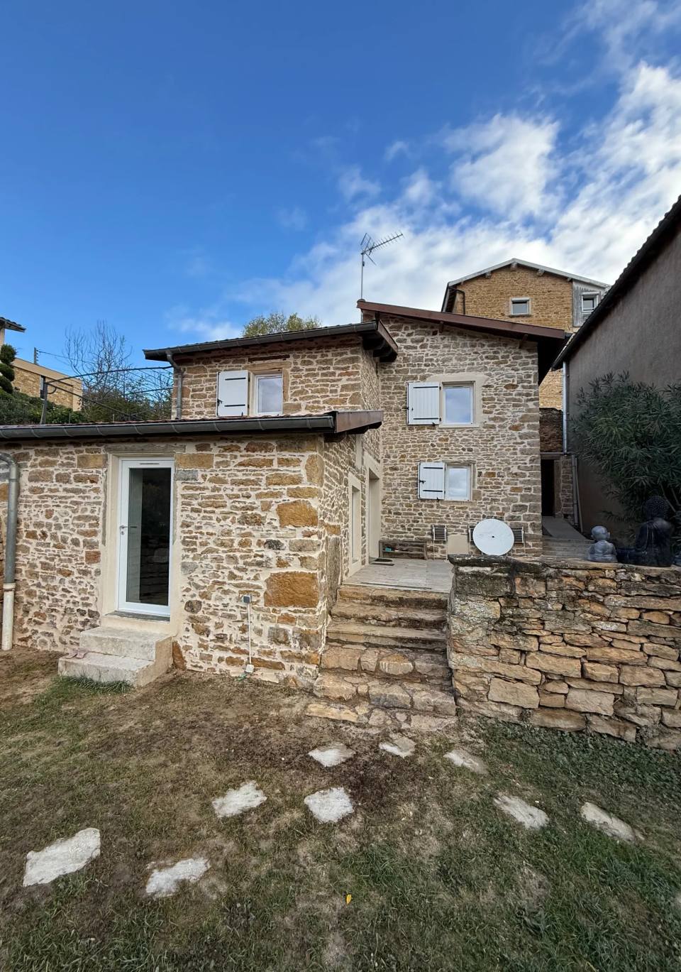 Maison, dépendance et murets en pierre dorée.