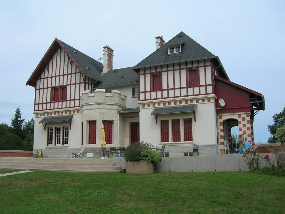 Villa à colombages rouges, façade blanche remise à neuf